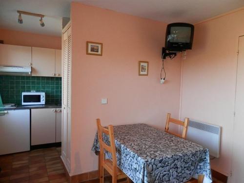 una piccola cucina con tavolo e forno a microonde di Studio Vieux-Boucau-les-Bains, 1 pièce, 2 personnes - FR-1-379-32 a Vieux-Boucau-les-Bains