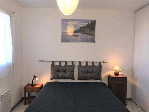 a bedroom with a large bed and a lamp at Appartement Vieux-Boucau-les-Bains, 2 pièces, 4 personnes - FR-1-379-74 in Vieux-Boucau-les-Bains