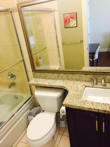 a bathroom with a toilet and a sink and a mirror at Imperial House in Burnaby