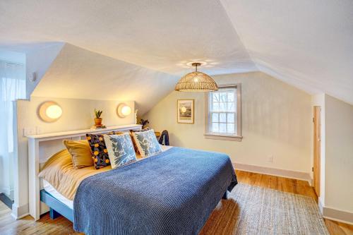 1 dormitorio con 1 cama con edredón azul y ventana en Saugerties Home 3 Decks and Hudson River View en Saugerties