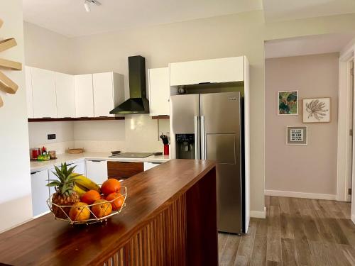 a kitchen with a bowl of fruit on a counter at Tropical beachfront apartment in Belle Mare