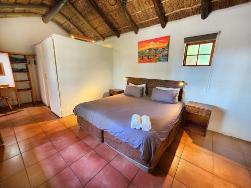 a bedroom with a bed with two flip flops on it at Pine Valley in Lanseria