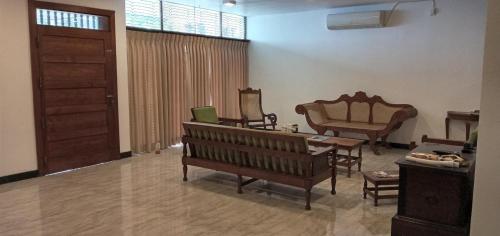 a living room with wooden benches and a table at Heritage Villa colombo7 in Colombo