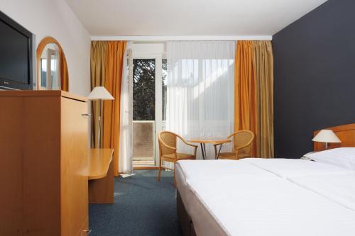 une chambre d'hôtel avec un lit et une table dans l'établissement OREA Hotel Voro Brno, à Brno