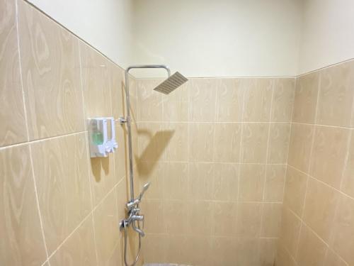 a shower with a shower head in a bathroom at Hotel Tonapa Prince Sorowako Mitra RedDoorz in Malili