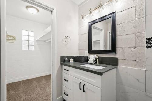 a white bathroom with a sink and a mirror at Elsie House *great family spot* in Las Vegas
