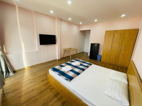 a bedroom with a bed and a tv on the wall at Aspire Saigon - Ly Tu Trong in Ho Chi Minh City