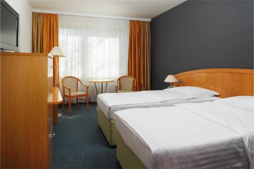 a hotel room with two beds and a table at OREA Hotel Voro Brno in Brno
