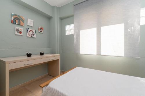 a bedroom with a bed and a desk and a window at Arsas Suites in Nikiti