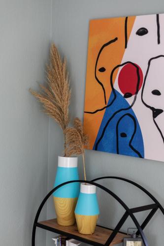 a shelf with three vases and a painting on the wall at Arsas Suites in Nikiti