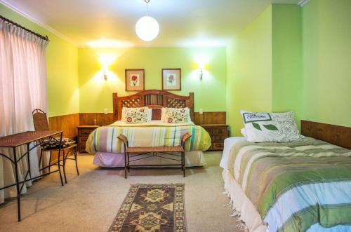 um quarto com 2 camas, uma mesa e cadeiras em Hostal Cepa Noble em Santa Cruz
