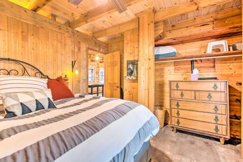 ein Schlafzimmer mit einem Bett und einer Holzwand in der Unterkunft Charming Lake Sinclair Cabin Fire Pit, Dock in Sparta