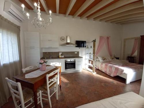 1 dormitorio y sala de estar con mesa de comedor. en Monolocale in campagna vicino Bolgheri e mare, en Cecina