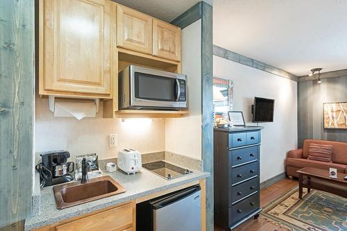 a small kitchen with a sink and a microwave at Mountainside Inn 116 Hotel Room in Telluride