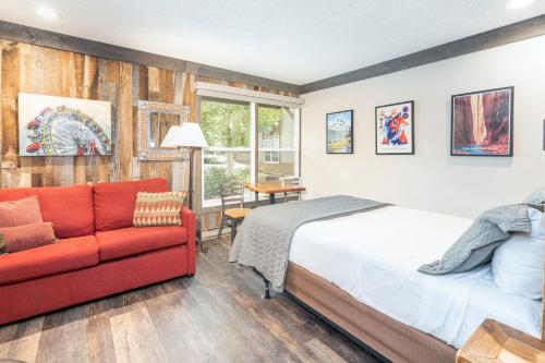 a bedroom with a bed and a red couch at Mountainside Inn 412 by Alpine Lodging Telluride in Telluride