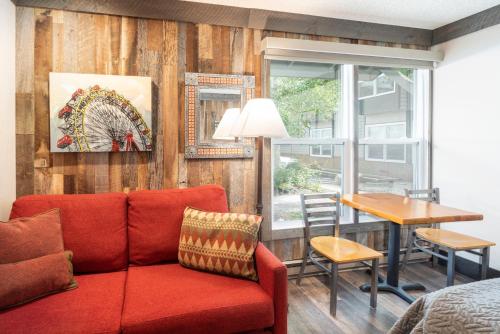 a living room with a red couch and a table at Mountainside Inn 412 by Alpine Lodging Telluride in Telluride