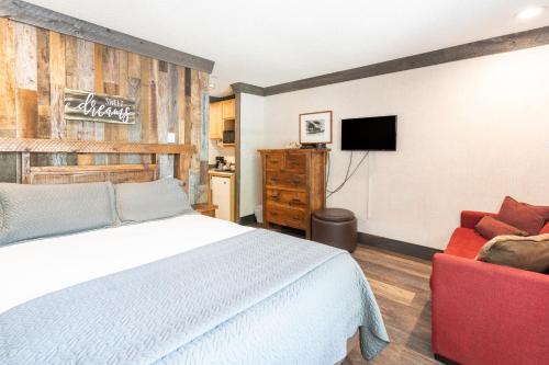 a bedroom with a white bed and a red chair at Mountainside Inn 412 by Alpine Lodging Telluride in Telluride