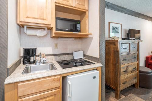 a small kitchen with a sink and a microwave at Mountainside Inn 412 by Alpine Lodging Telluride in Telluride