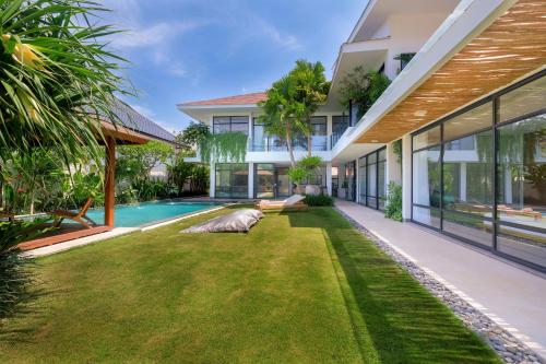 an exterior view of a house with a yard at Villa Nonnavana - 12-minute walk to Batu Bolong Beach in Canggu