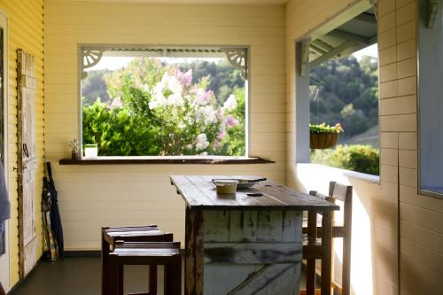 a table in a screened in porch with a window at CedarBrae Country Stay in Gympie