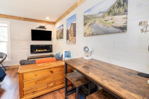 een woonkamer met een houten tafel en een open haard bij Mountainside Inn 310 Hotel Room in Telluride