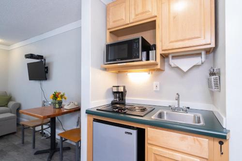 a small kitchen with a sink and a microwave at Mountainside Inn 408 Hotel Room in Telluride