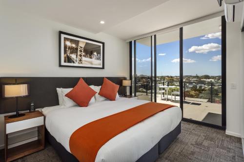 a bedroom with a large bed with a large window at Quest Woolloongabba in Brisbane