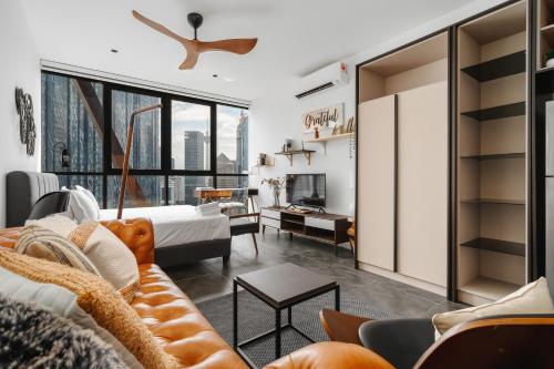 ein Wohnzimmer mit einem Sofa und einem Bett in der Unterkunft Scarletz KLCC Apartments by soulasia in Kuala Lumpur