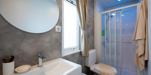 a bathroom with a sink and a toilet and a window at Camping villaggio L'Ultima spiaggia in Bari Sardo