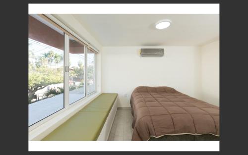 - une chambre avec un lit et une grande fenêtre dans l'établissement Room in Apartment - Apartment Rodolfo Historic Center, à Mazatlán