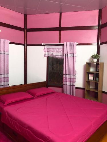 ein rosafarbenes Schlafzimmer mit einem großen Bett mit rosafarbener Bettwäsche in der Unterkunft Homestay Pink House (Ngôi nhà màu hồng) in Ấp Ðông Qứi