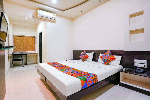 a bedroom with a bed and a desk in a room at FabHotel Regent Inn - Nr SkyWalk Bridge in Pune