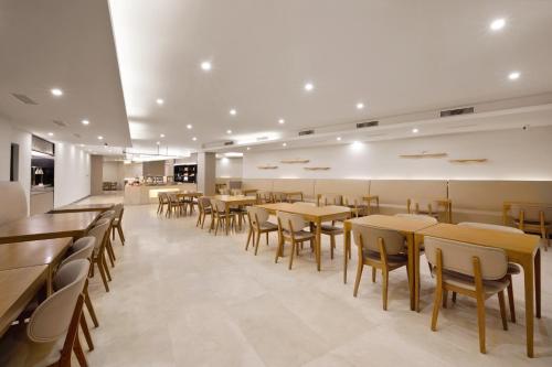 a dining room with wooden tables and chairs at Hanting Hotel Chongqing Niujiaotuo Railway Station in Chongqing