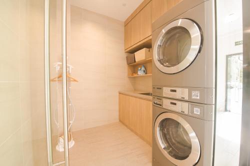 a laundry room with a washer and dryer at Hanting Hotel Chengdu Yushuang Road Subway Station in Chengdu
