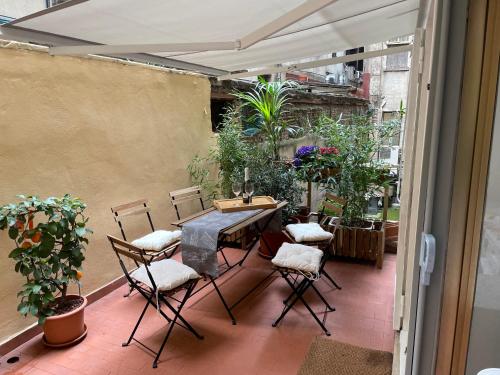 patio con mesa y sillas en el balcón en CASA ANTICA - antique apartment with private terrace, en Roma