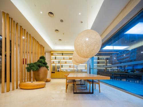 a table and chairs in a lobby with a pool at JI Hotel Chengdu Wuhouci Branch in Chengdu