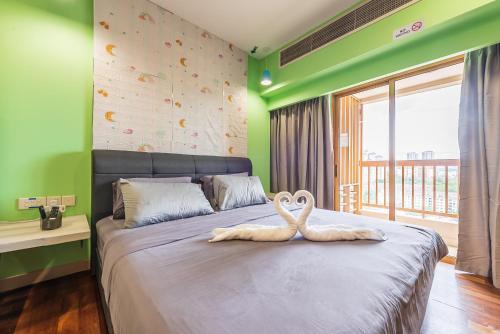a bedroom with a bed with two swans on it at Resort Suites Pyramid & Lagoon in Petaling Jaya