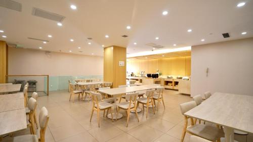 a restaurant with tables and chairs and a kitchen at JI Hotel Nanjing Hongqiao Zhongshan North Road in Nanjing