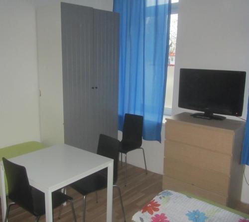 a living room with a white table and a television at Apartments Messe-Prater in Vienna