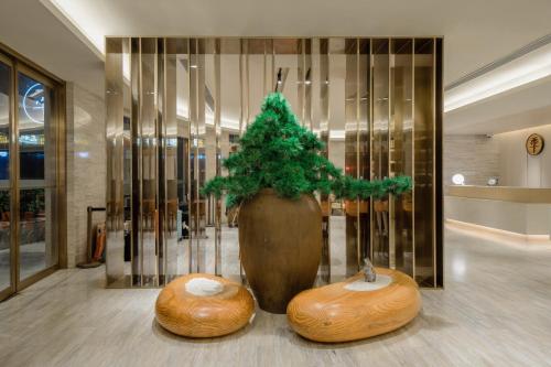 a large vase with a potted plant in a lobby at Ji Hotel Shanghai The Bund Jinling East Road in Shanghai