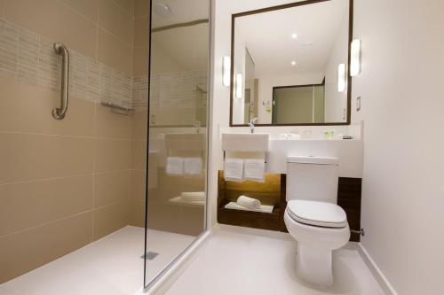 a bathroom with a toilet and a glass shower at Bugan Recife Boa Viagem Hotel - by Atlantica in Recife