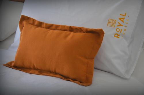 a brown pillow sitting on top of a bed at Hotel Royal in Colonia del Sacramento