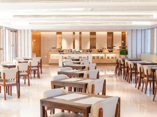 a restaurant with tables and chairs and a counter at JI Hotel Xiamen University in Xiamen