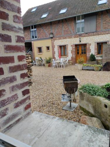 a brick building with a grill in the courtyard at Le Val d'Andé in Andé