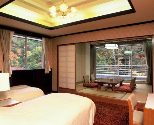 1 dormitorio con cama, mesa y ventana en Gensenkan, en Nasushiobara