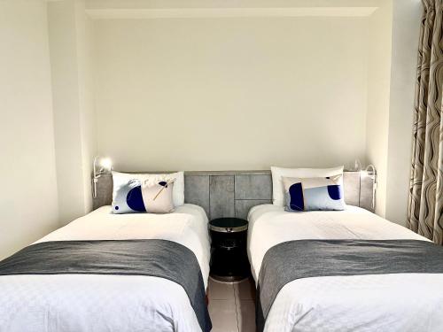 two beds sitting next to each other in a room at 湯園民宿 l 民宿編號1639 in Taitung City