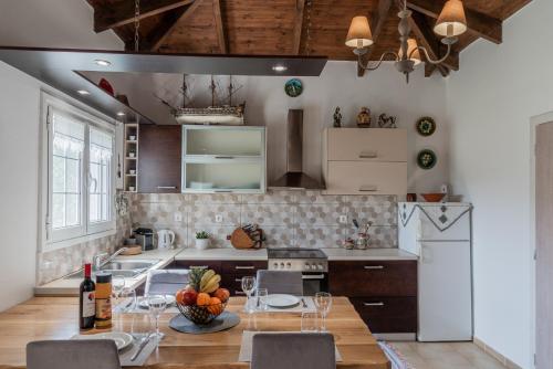 Pandokrátor的住宿－Armando Cottage，带桌椅的厨房以及带白色家电的厨房。