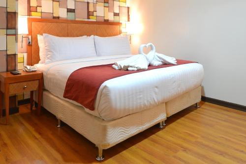 a bedroom with a bed with a teddy bear on it at Royal Suites Condotel in Kalibo