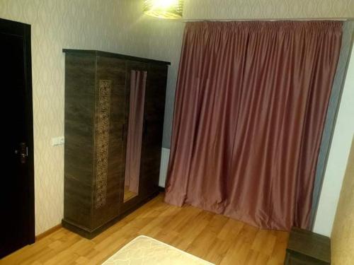 sala de estar con cortina roja y suelo de madera en Срочно Сдаётся!!!, en Tiflis