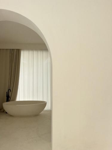 a bathroom with a white tub in front of a window at Calamus Luxury Villa in Umalas Private Pool in Canggu
